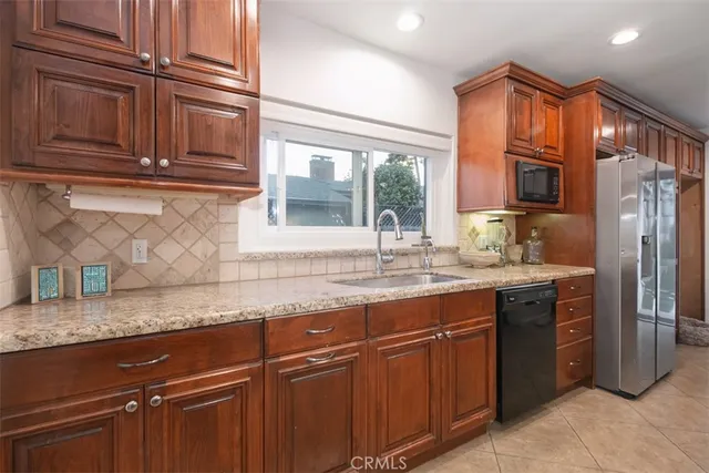 a kitchen with granite countertop wooden cabinets and stainless steel appliances