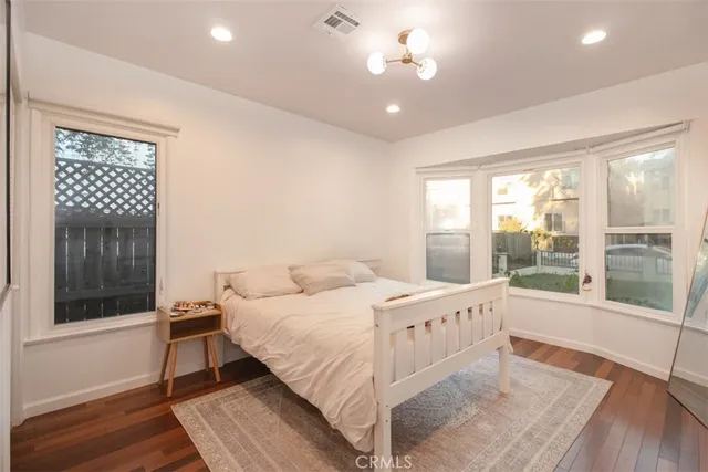 a backyard of a house with table and chairs with plants and wooden fence