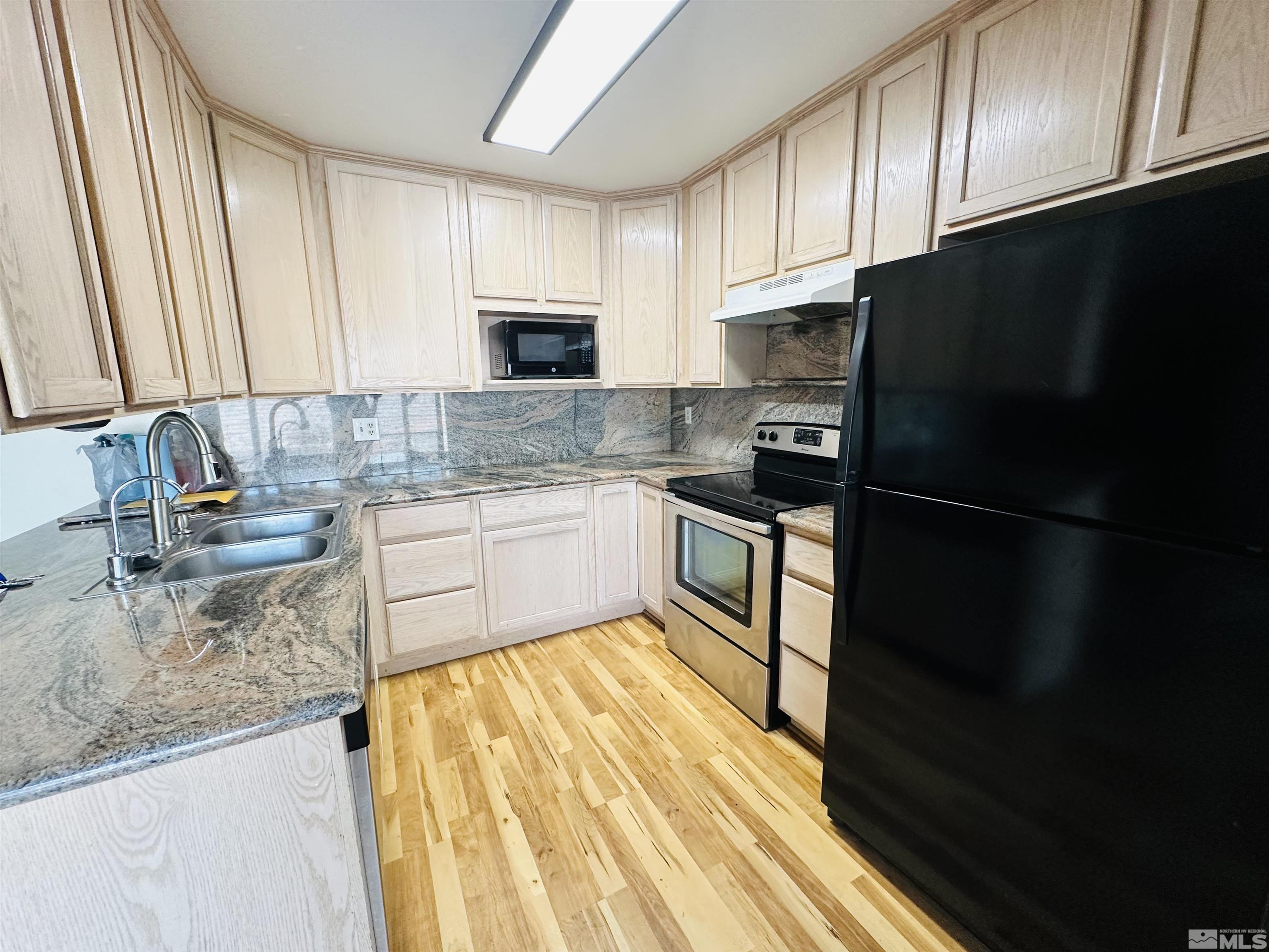 32 Castle Way Carson City, NV 89706 - Photo 4 of 16 a kitchen with granite countertop stainless steel appliances a sink a refrigerator and cabinets