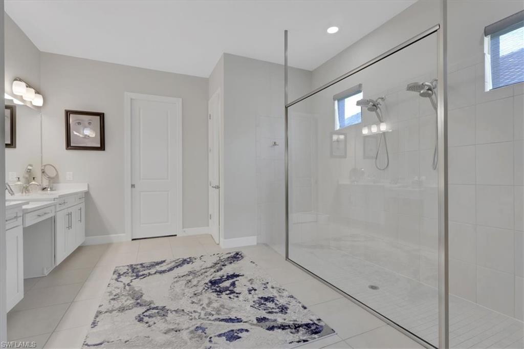 3221 Quilcene Lane Naples, FL 34114 - Photo 17 of 42 a bathroom with a bathtub shower sink and mirror