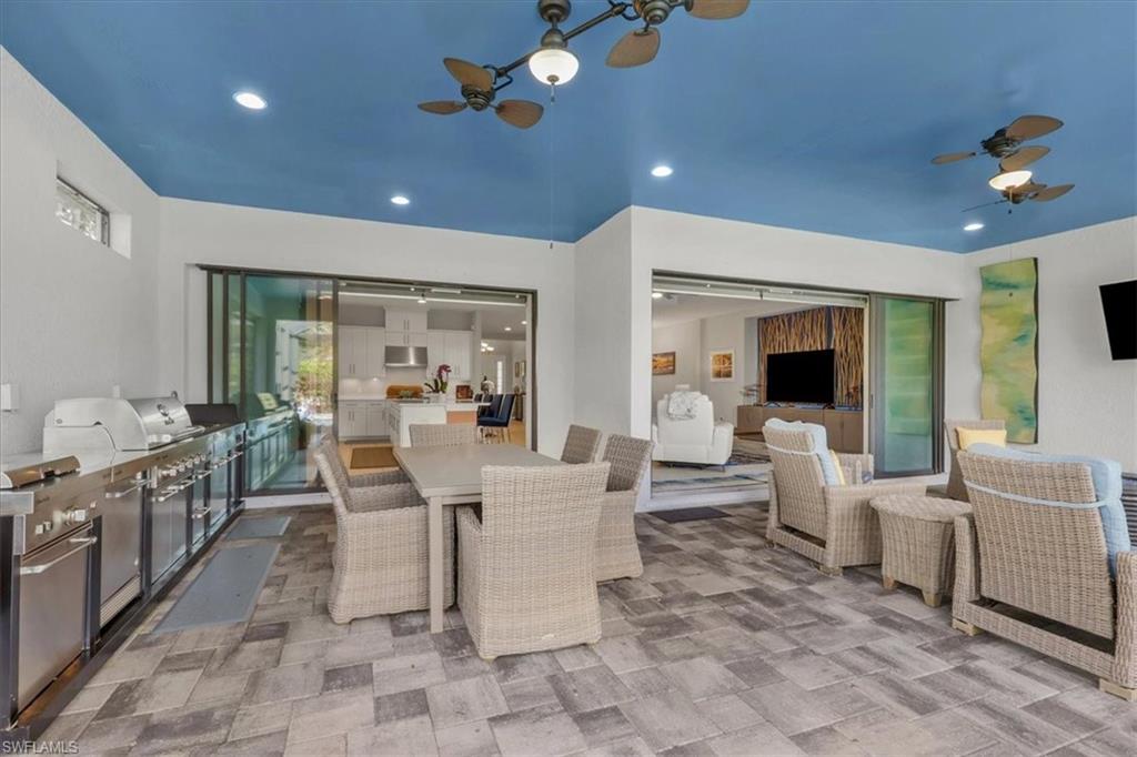 3221 Quilcene Lane Naples, FL 34114 - Photo 26 of 42 a living room with furniture a chandelier and a dining table