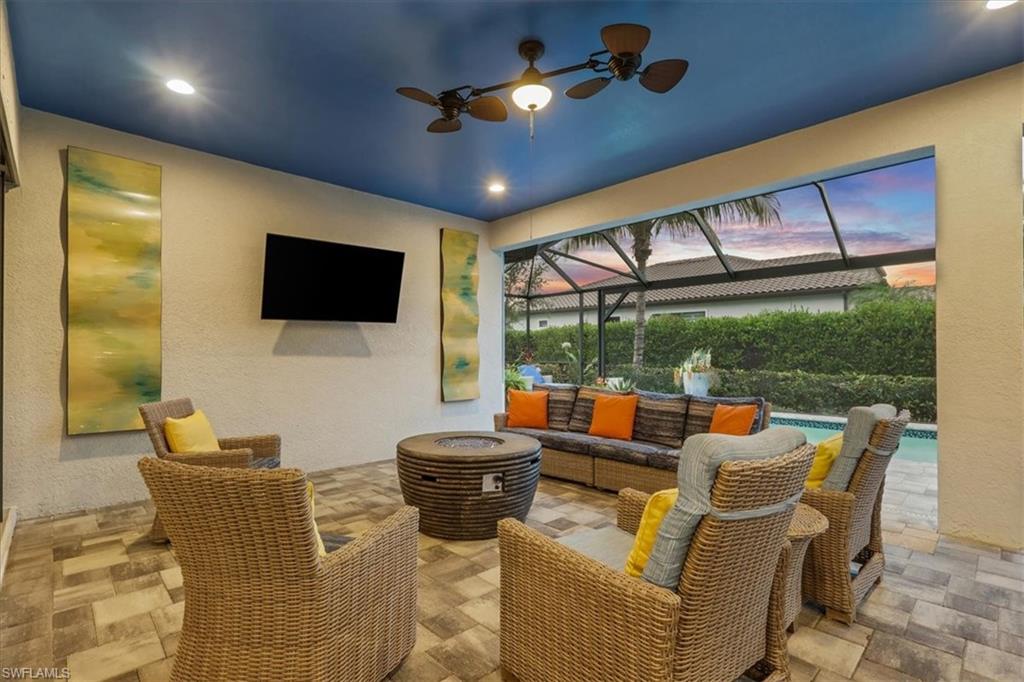 3221 Quilcene Lane Naples, FL 34114 - Photo 33 of 42 a living room with patio furniture and a flat screen tv
