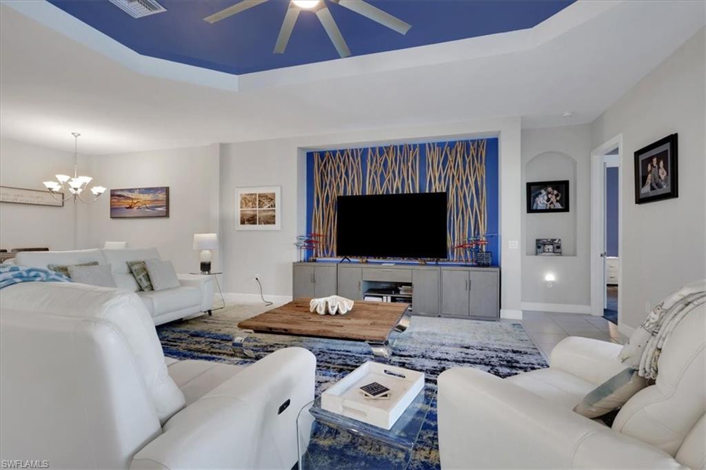 3221 Quilcene Lane Naples, FL 34114 - Photo 6 of 42 a living room with furniture and a flat screen tv