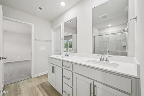 a bathroom with double sink and a mirror