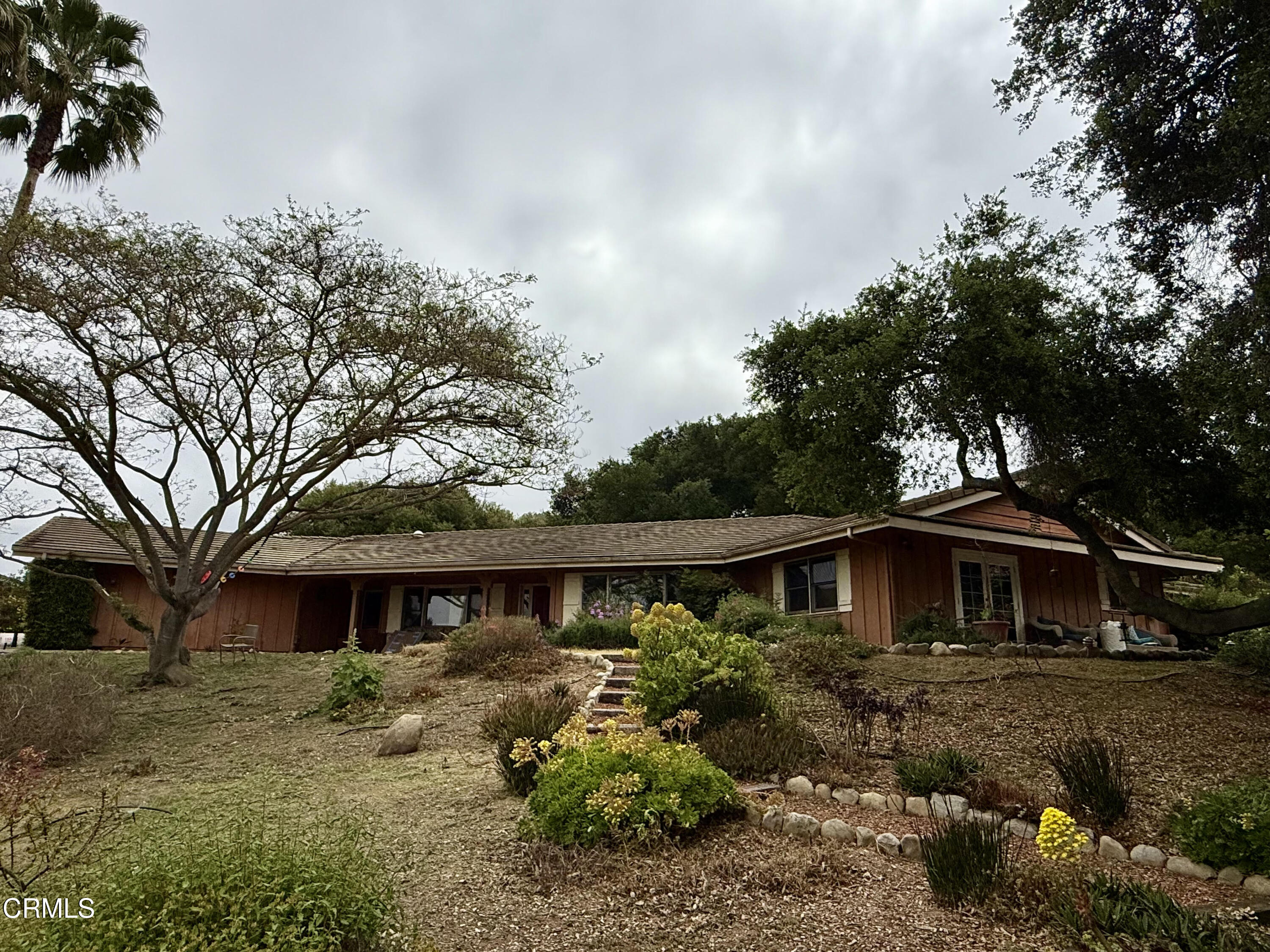 a front view of a house with a garden