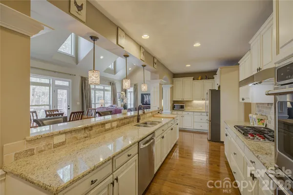 a large kitchen with stainless steel appliances granite countertop a sink and a stove