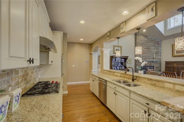 a kitchen with stainless steel appliances granite countertop a dining table chairs and granite counter tops