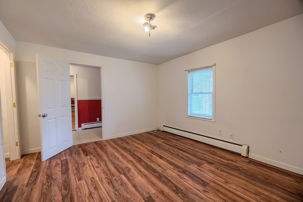 201 Stone Street Clinton, MA 01510 - Photo 20 of 42 an empty room with wooden floor and fan