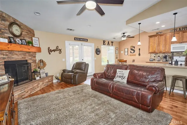 a living room with furniture a wooden floor and kitchen view