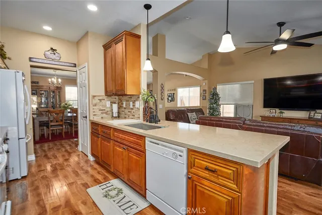 a kitchen with stainless steel appliances kitchen island granite countertop a table chairs and a view of living room