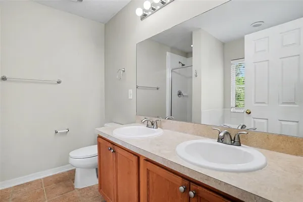 a bathroom with a granite countertop sink a toilet and a large mirror