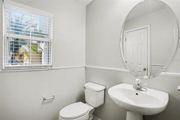 a bathroom with a sink mirror and toilet