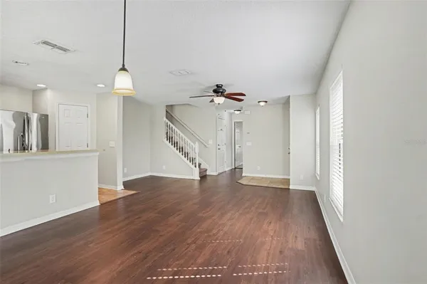 a view of a room with wooden floor staircase and a kitchen