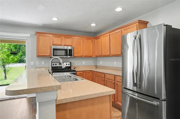 a kitchen with a refrigerator a microwave a sink and a stove