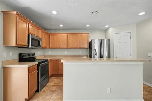a kitchen with stainless steel appliances granite countertop a refrigerator a stove top oven a sink and dishwasher