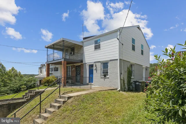 a front view of house with yard and trees in the background