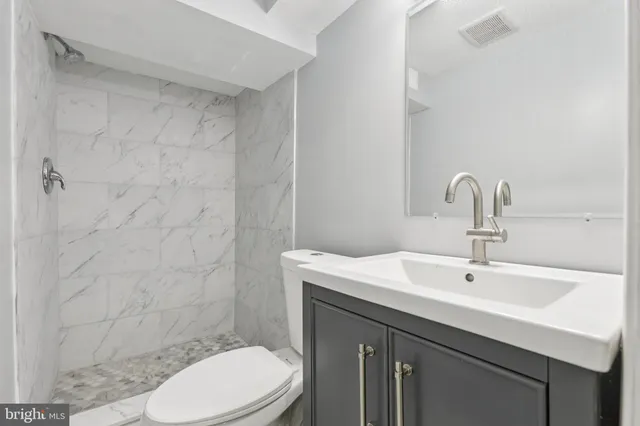 a bathroom with a sink a toilet and shower