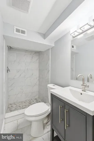 a bathroom with a sink a toilet and shower