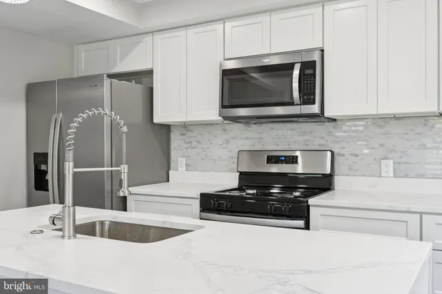 a kitchen with granite countertop a sink and a stove top oven