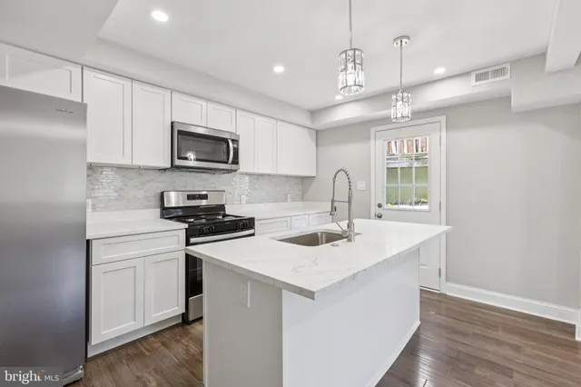 a kitchen with a sink a microwave a stove and refrigerator