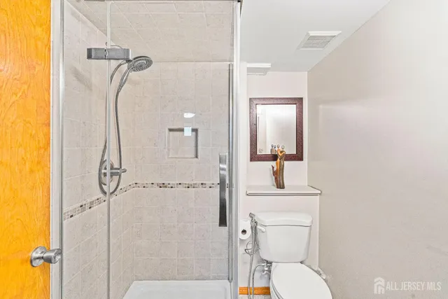 a bathroom with a sink vanity mirror and toilet