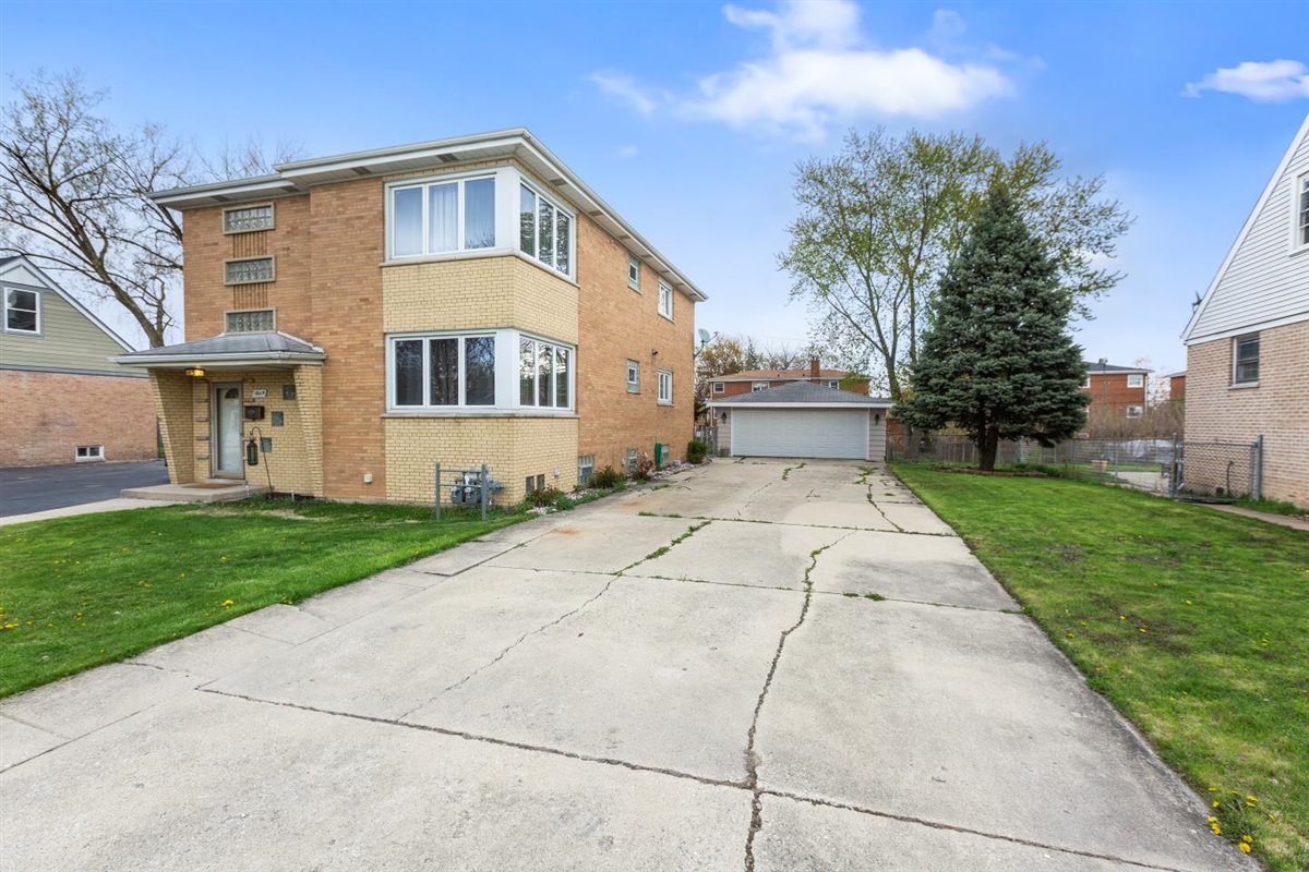 10619 Mason Avenue Chicago Ridge, IL 60415 - Photo 3 of 29 a front view of a house with a yard and garage