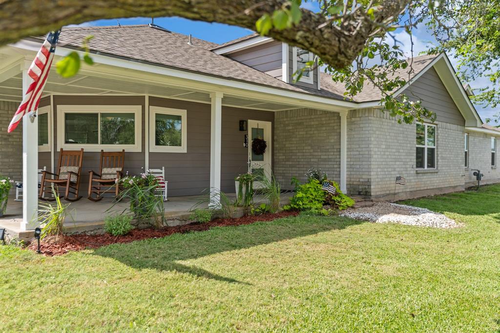 310 Edwards Street Riesel, TX 76682 - Photo 1 of 1 View of front facade with a front yard, roof with shingles, brick siding, and a patio