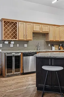 a kitchen with stainless steel appliances granite countertop a stove a sink dishwasher and cabinets with wooden floor