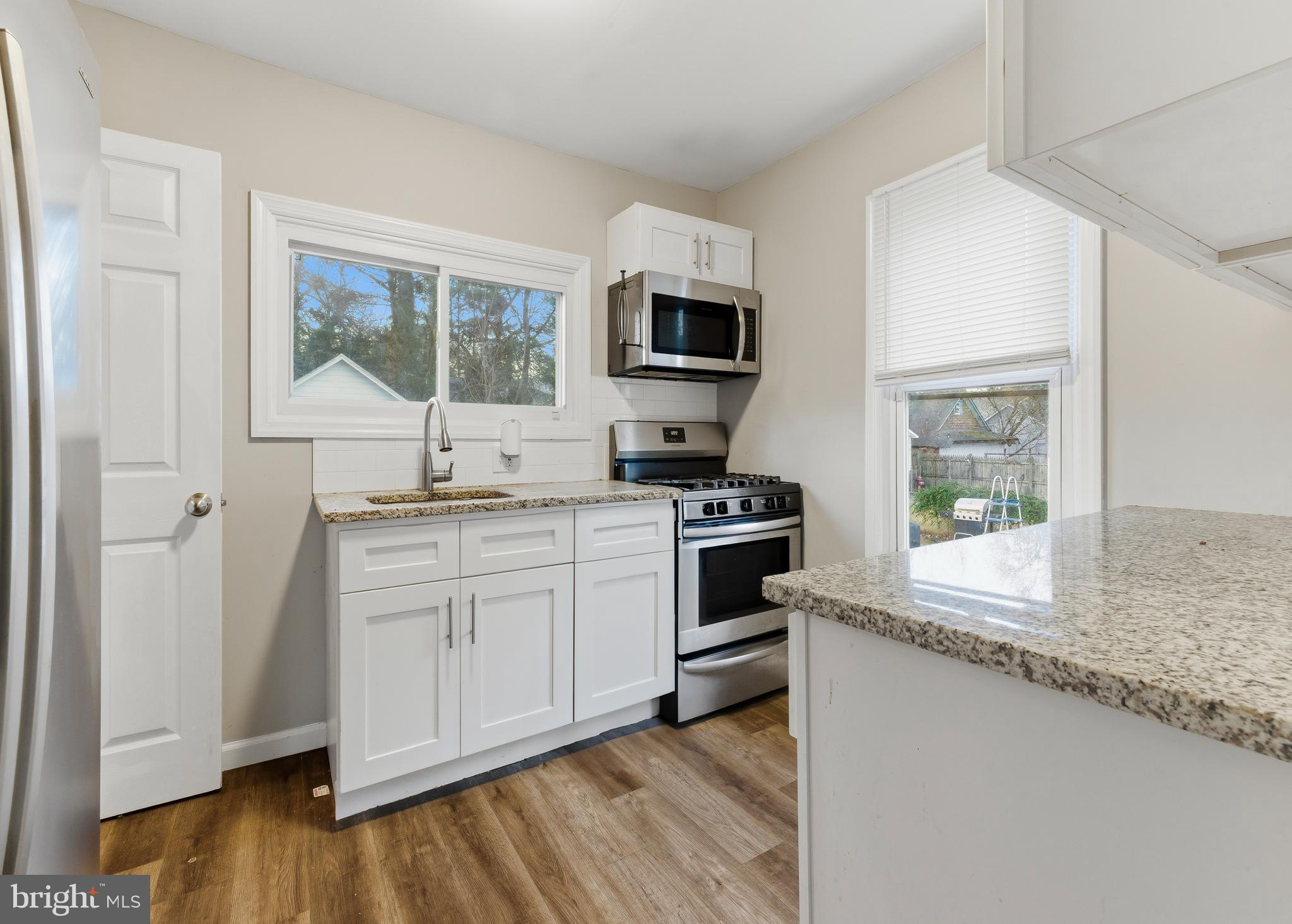 206 West 5th Avenue Runnemede, NJ 08078 - Photo 4 of 14 a kitchen with stainless steel appliances granite countertop a stove a sink and a microwave