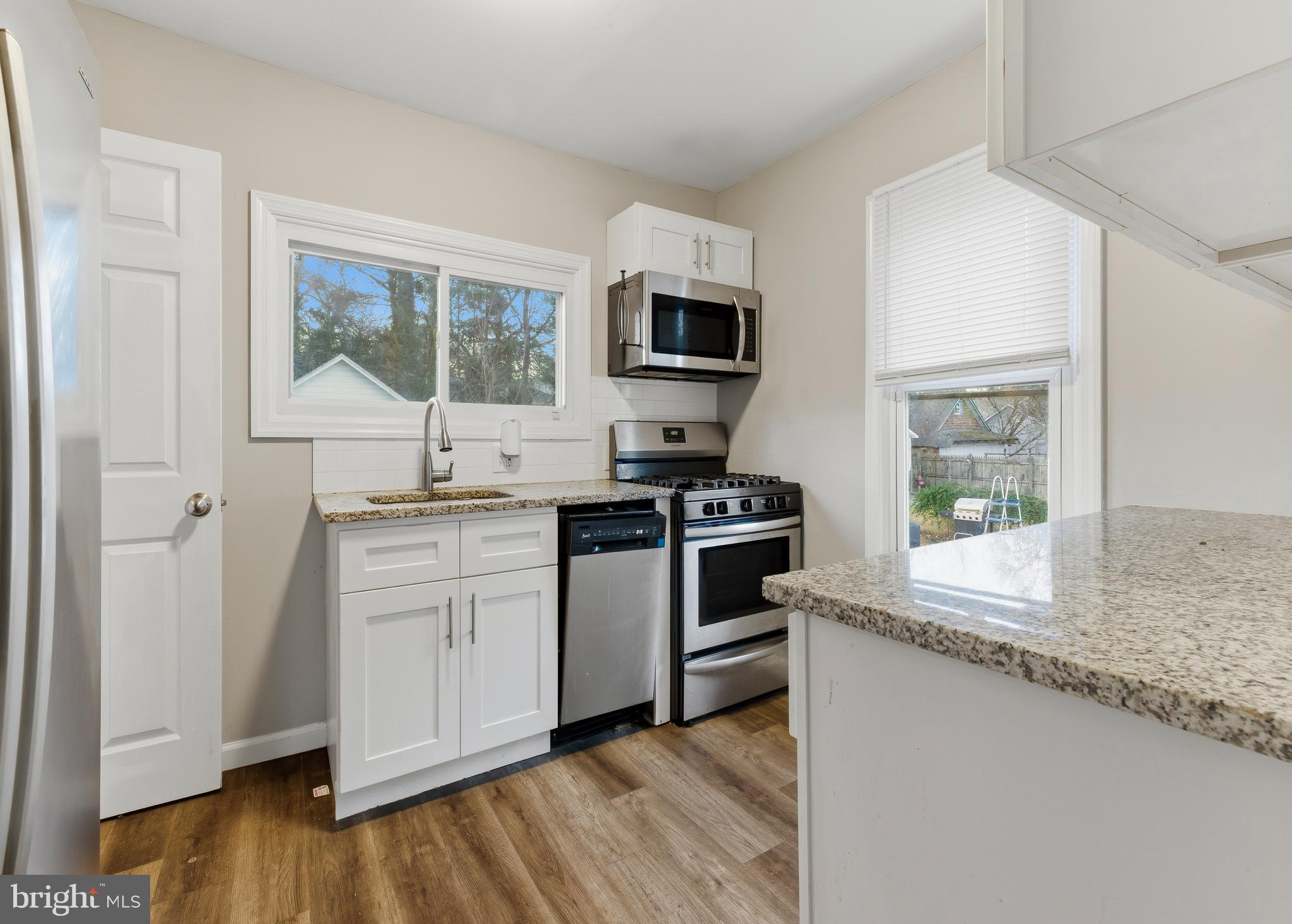 206 West 5th Avenue Runnemede, NJ 08078 - Photo 5 of 14 a kitchen with granite countertop a stove a sink and a microwave