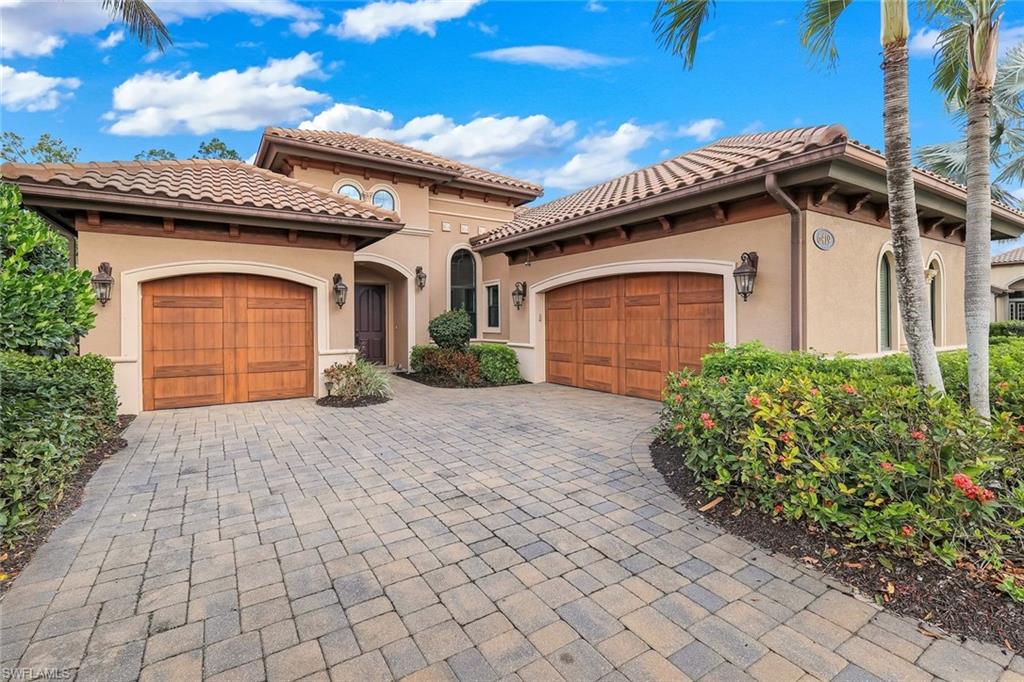 Mediterranean / spanish-style home featuring a garage, stucco siding, decorative driveway, and a tiled roof