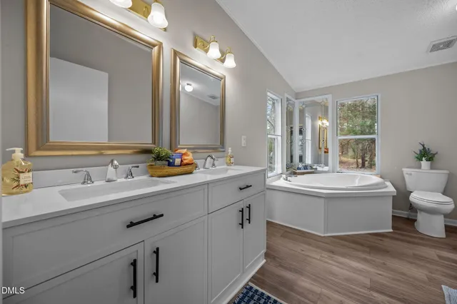 a bathroom with a granite countertop sink mirror and a bathtub