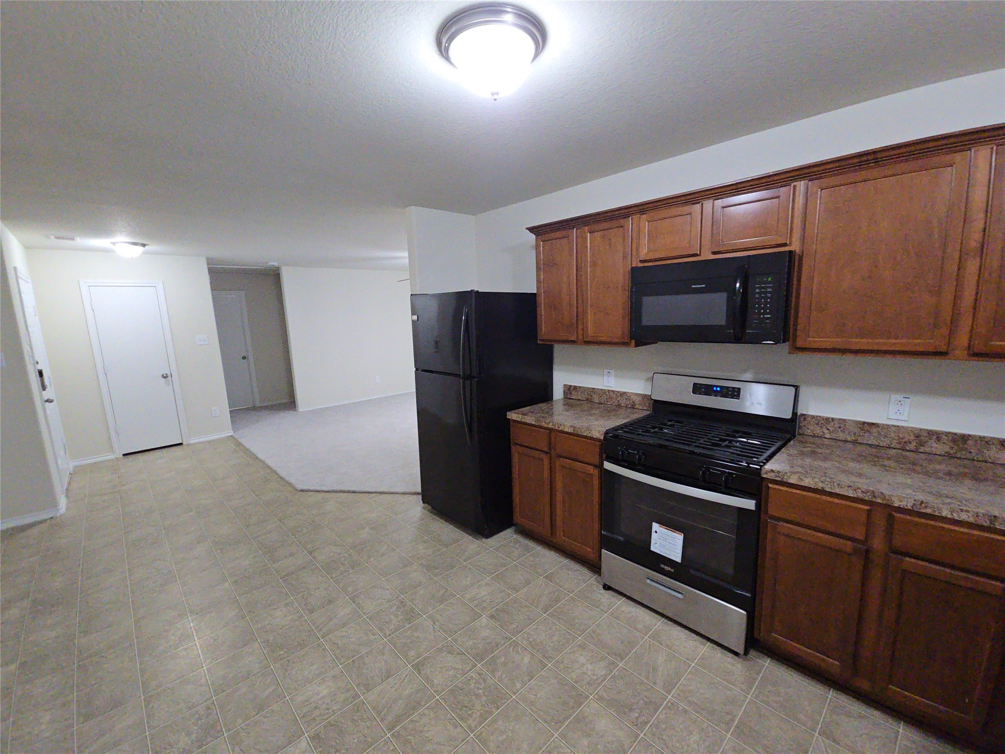 810 Lightningbug Lane Conroe, TX 77301 - Photo 5 of 27 a kitchen with stainless steel appliances granite countertop a refrigerator stove and sink