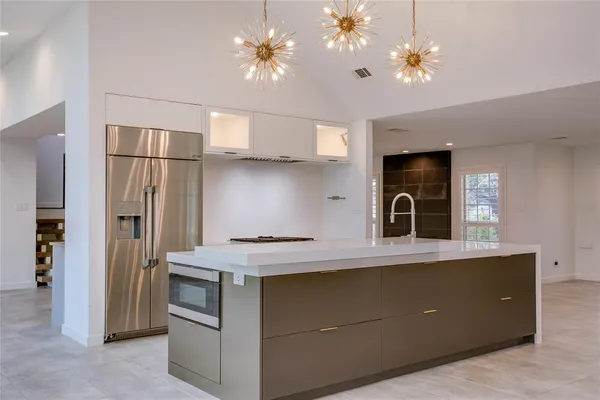 a kitchen with stainless steel appliances granite countertop a refrigerator a sink dishwasher a stove and a refrigerator