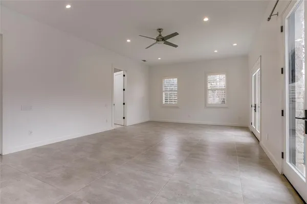 an empty room with windows and ceiling fan