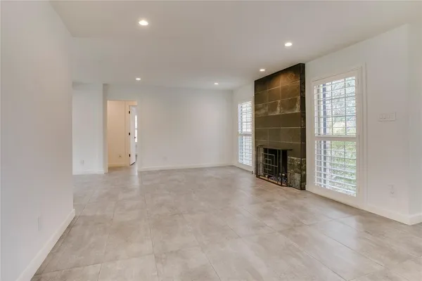 an empty room with fireplace and windows