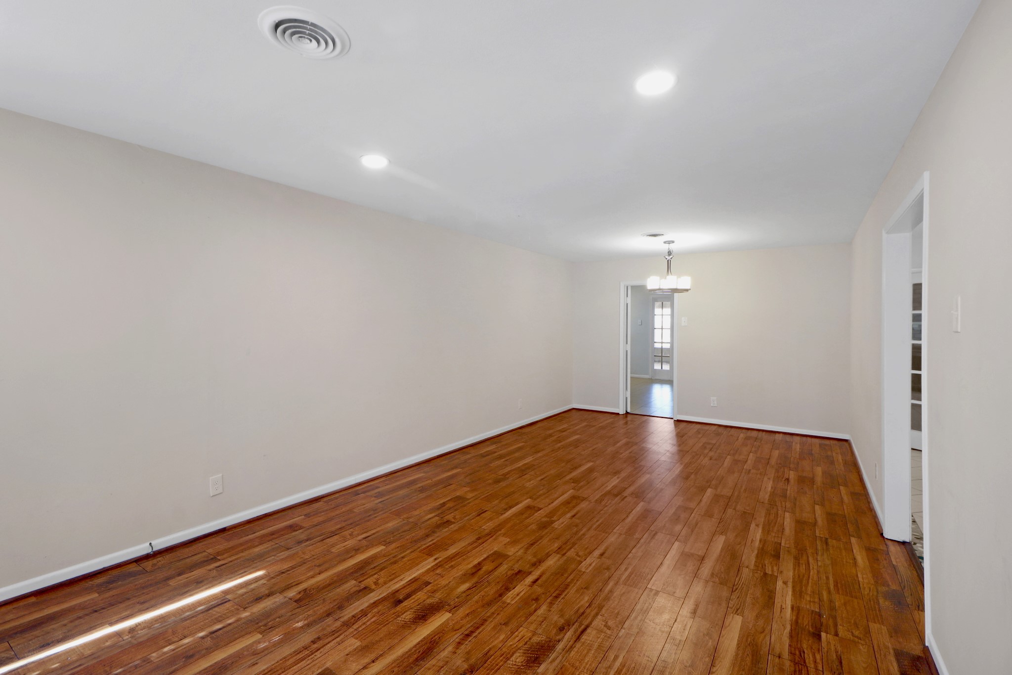 5554 Beechnut Street Houston, TX 77096 - Photo 2 of 30 a view of empty room with wooden floor and fan