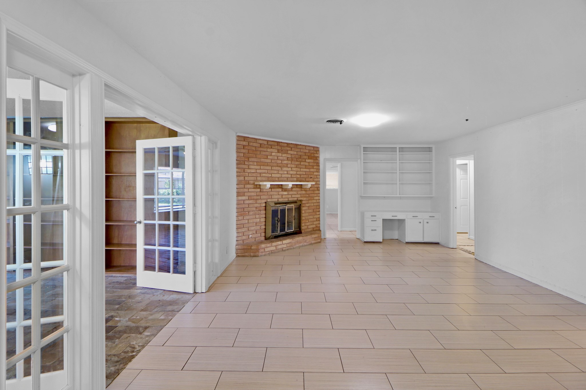 5554 Beechnut Street Houston, TX 77096 - Photo 6 of 30 an empty room with windows fireplace and cabinet