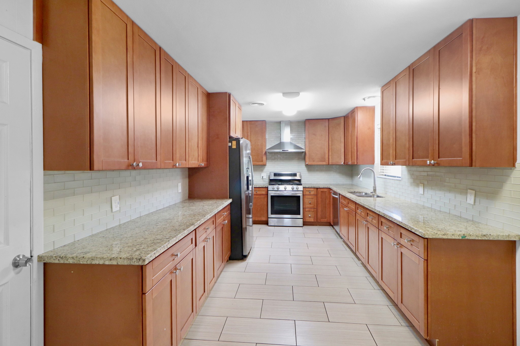 5554 Beechnut Street Houston, TX 77096 - Photo 7 of 30 a large kitchen with stainless steel appliances granite countertop a sink counter space cabinets and a large window