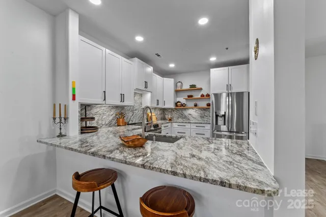 a kitchen with stainless steel appliances granite countertop a sink refrigerator and cabinets