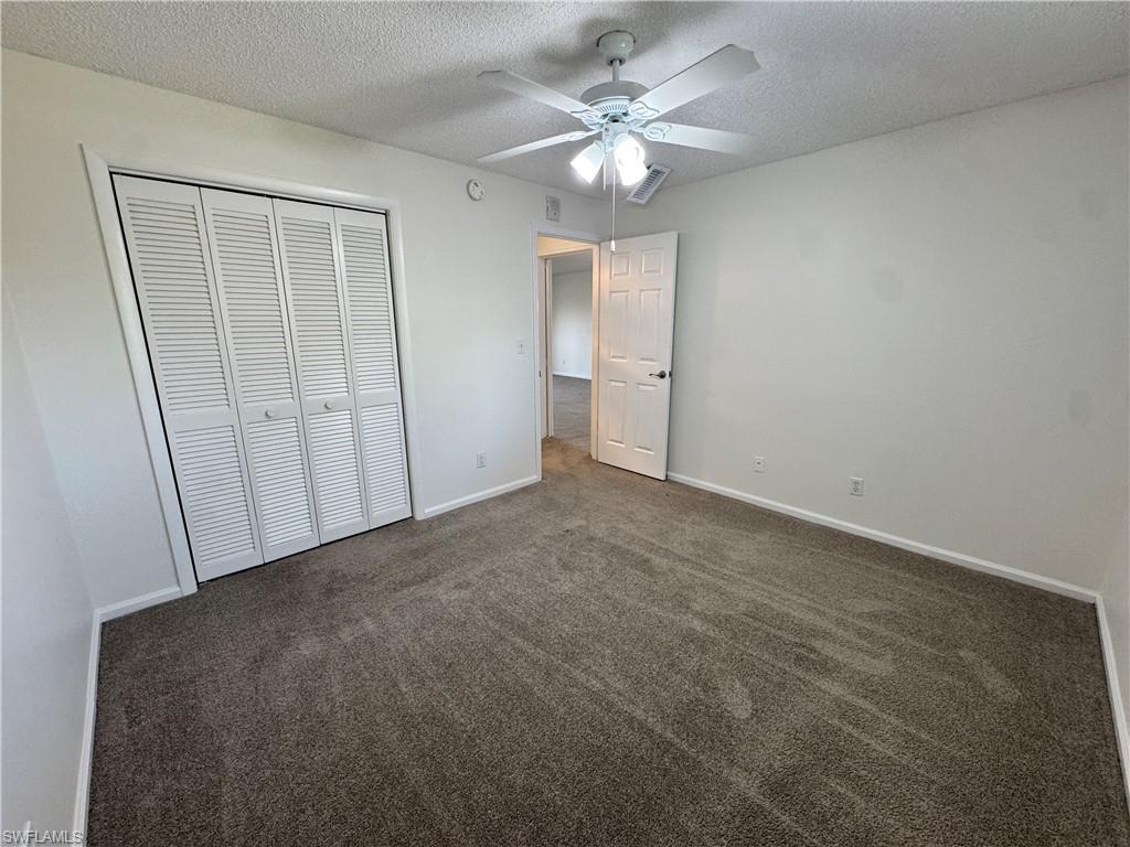 5667 Rattlesnake Hamm Road North, Unit B301 Naples, FL 34113 - Photo 14 of 17 an empty room with a ceiling fan and a bathroom