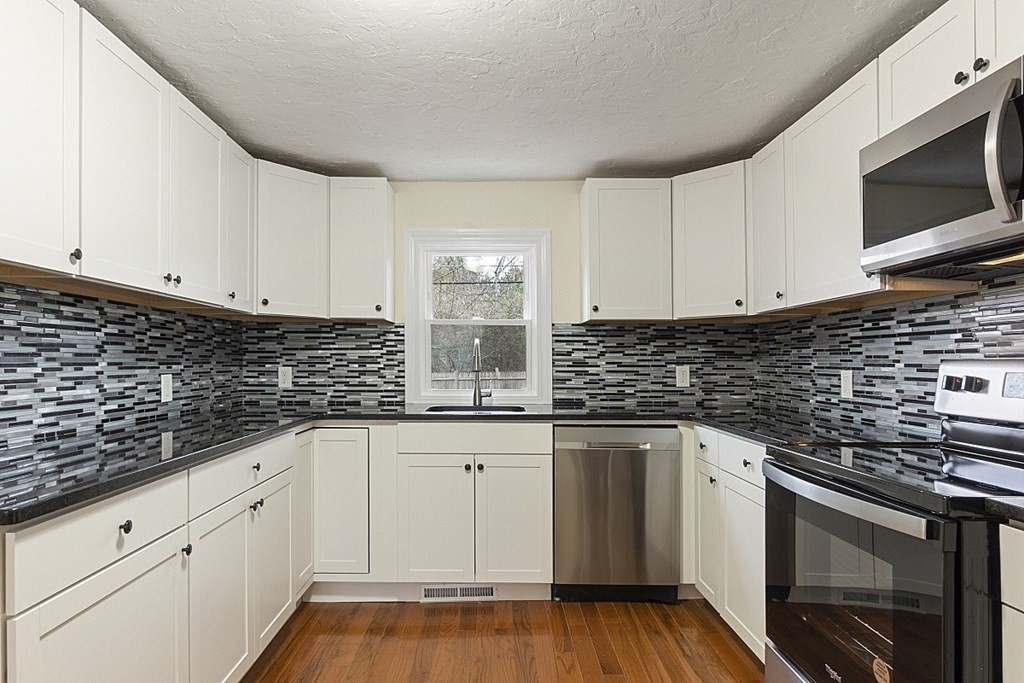 32 Elaine Street Webster, MA 01570 - Photo 20 of 42 a kitchen with granite countertop white cabinets stainless steel appliances a sink and dishwasher