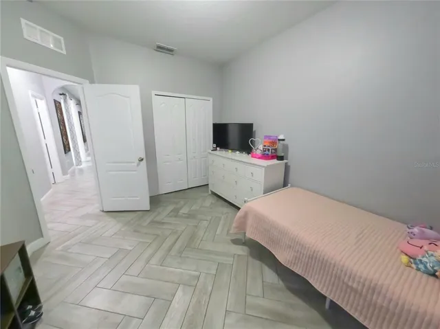 a bedroom with a bed and a flat screen tv