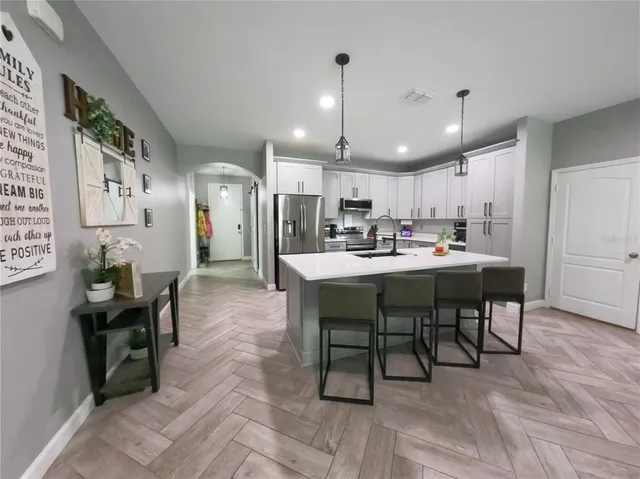 a living room with furniture a flat screen tv and a view of kitchen