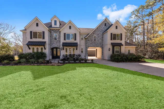 a front view of a house with a yard and trees