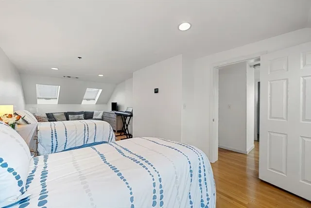 a spacious bedroom with two beds and wooden floor