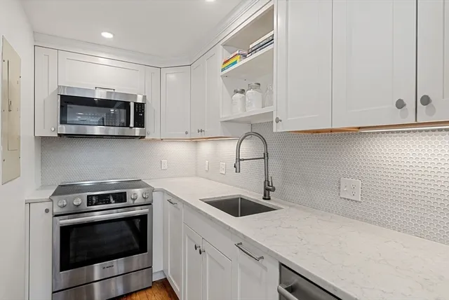 a kitchen with stainless steel appliances granite countertop a sink a stove a microwave and cabinets