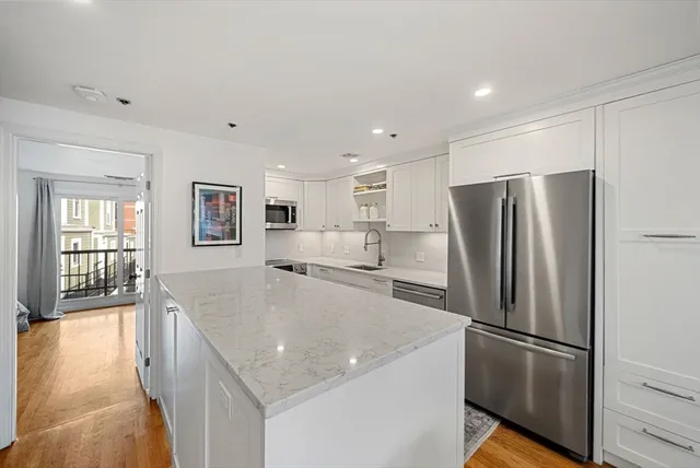 a kitchen with stainless steel appliances granite countertop a refrigerator and a stove top oven