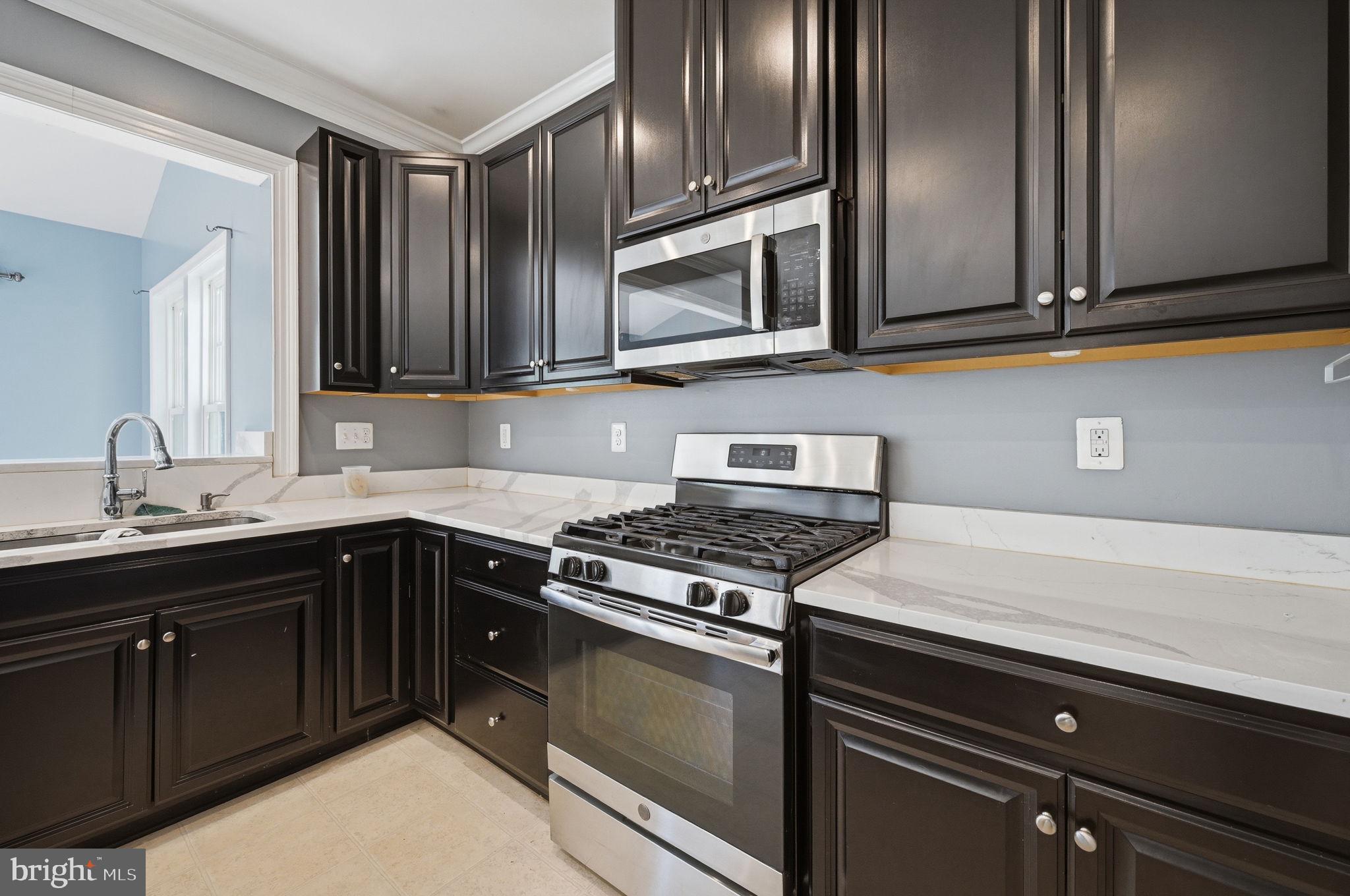 687 Blossom Tree Road Culpeper, VA 22701 - Photo 11 of 31 a kitchen with stainless steel appliances granite countertop a stove and a microwave