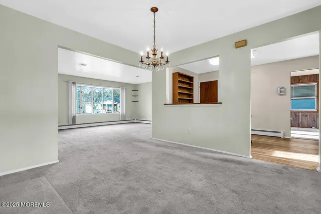 an empty room with windows and ceiling fan